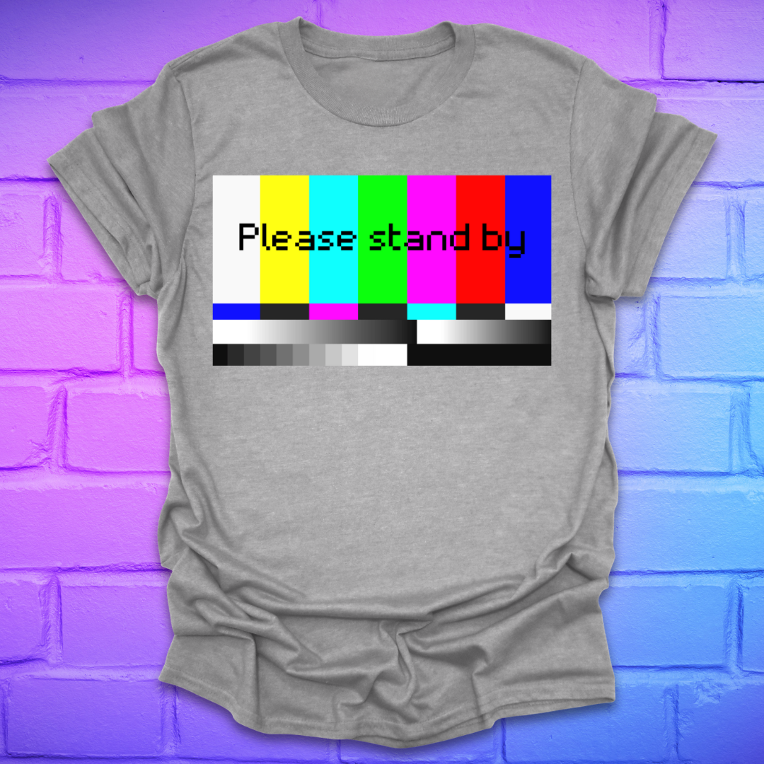 Gray t-shirt with a colorful 'Please stand by' graphic on a brick wall background