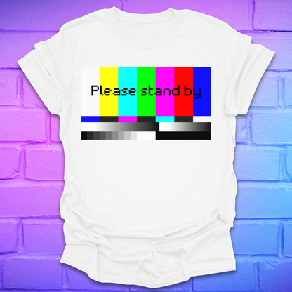 White t-shirt with 'Please stand by' graphic on a purple brick wall background