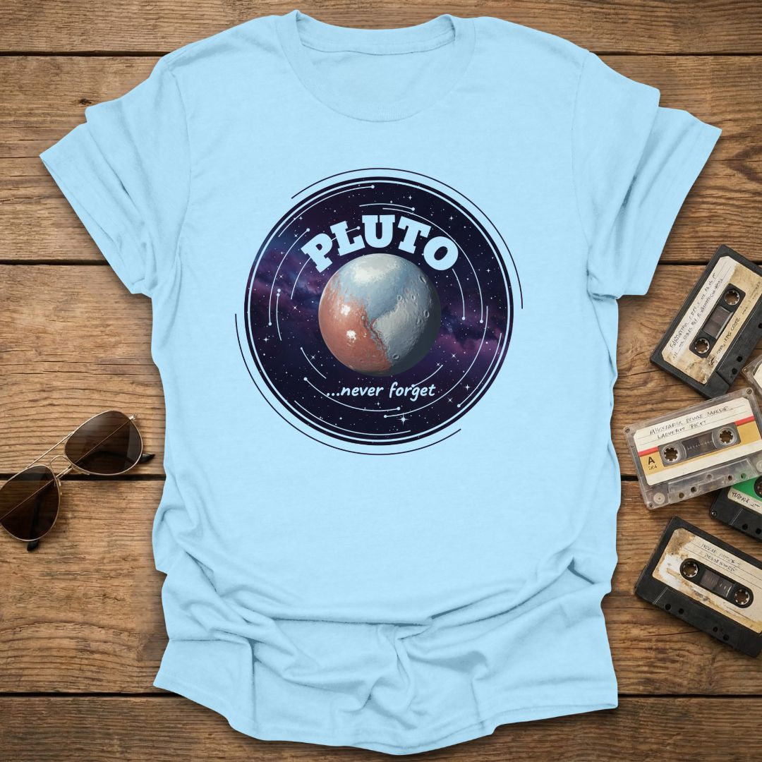 Light blue t-shirt with Pluto graphic on a wooden surface with sunglasses and cassettes.