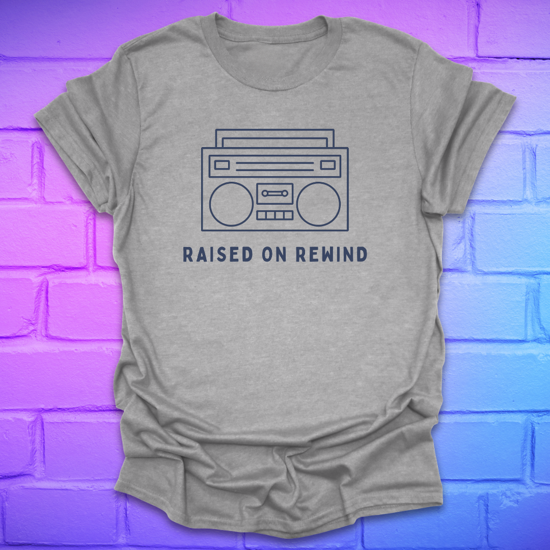 Gray t-shirt with a boombox graphic and 'Raised on Rewind' text on a brick wall background