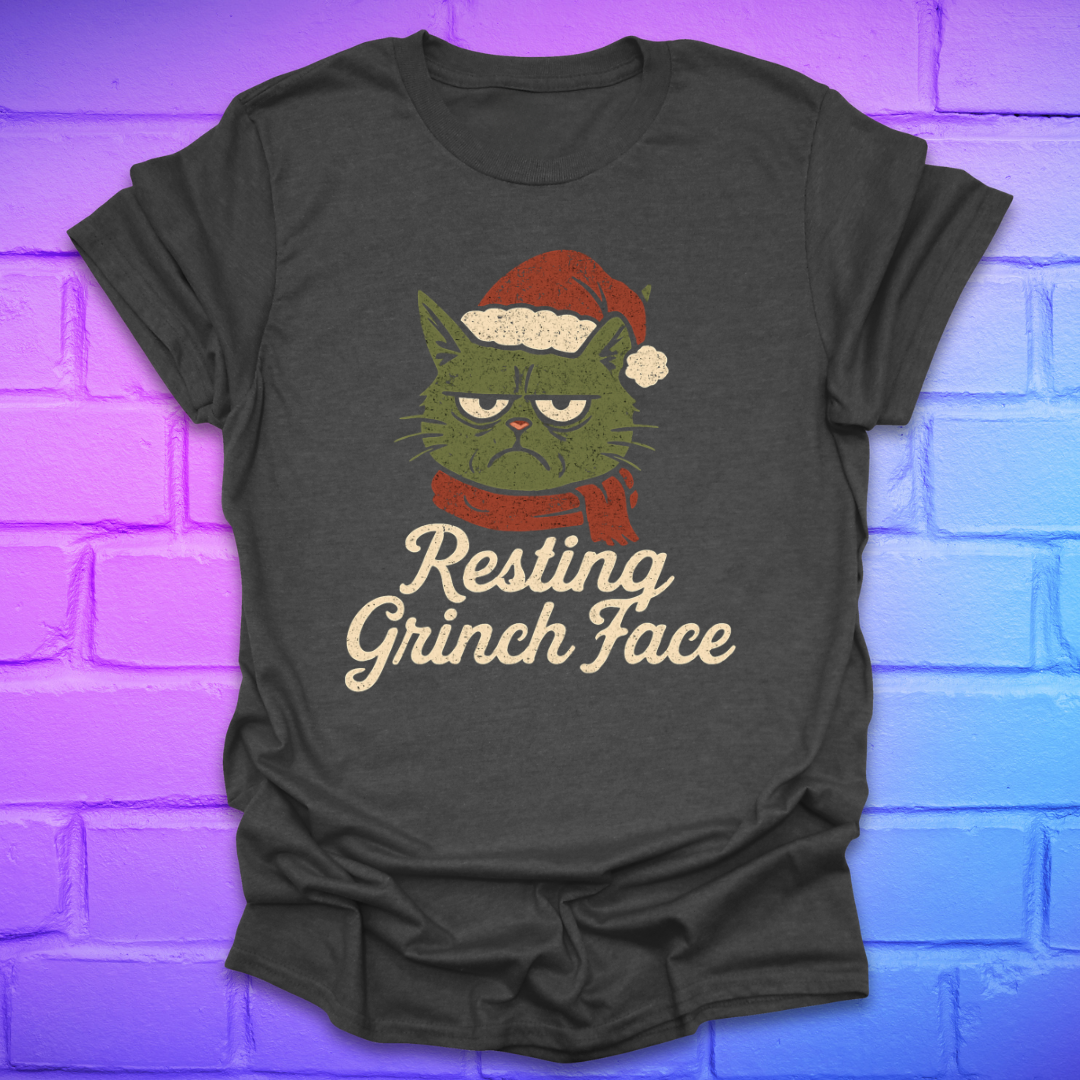 Dark gray t-shirt with a Grinch face  cat graphic and 'Resting Grinch Face' text on a brick wall background.
