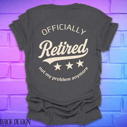Gray t-shirt with 'Officially Retired, not my problem anymore' text on a brick wall background