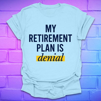 Light blue t-shirt with 'My Retirement Plan is Denial' text on a purple brick wall background