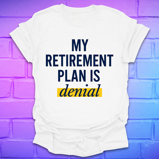 White t-shirt with 'My Retirement Plan is Denial' text on a purple brick wall background