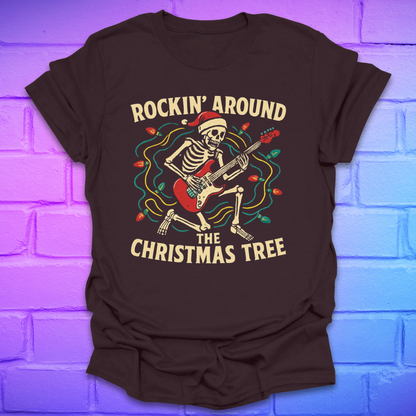 Brown t-shirt with skeleton playing guitar graphic and text 'Rockin' Around the Christmas Tree' on a brick wall background.