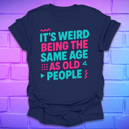 Navy t-shirt with colorful text, 'it's weird being the same age as old people' on a brick wall background