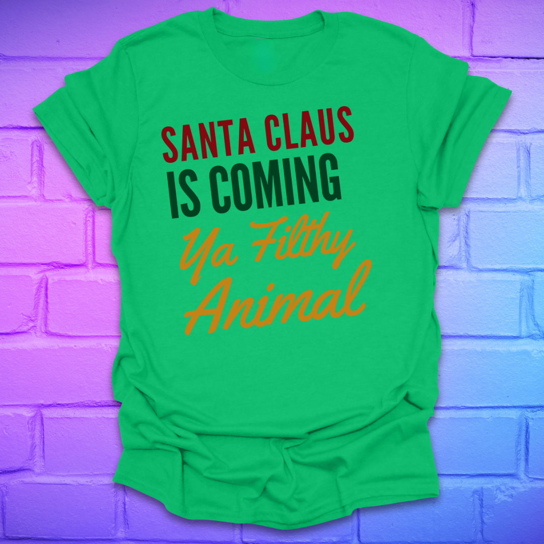 Green t-shirt with colorful text, 'santa claus is coming ya filthy animal' on a brick wall background