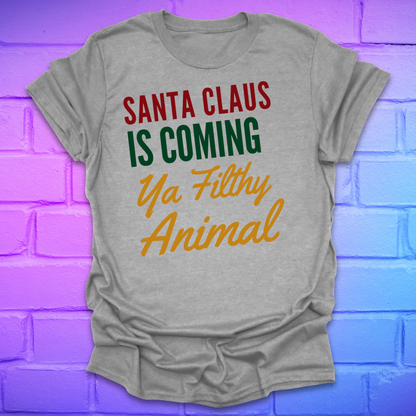  Grey t-shirt with colorful text, 'santa claus is coming ya filthy animal' on a brick wall background