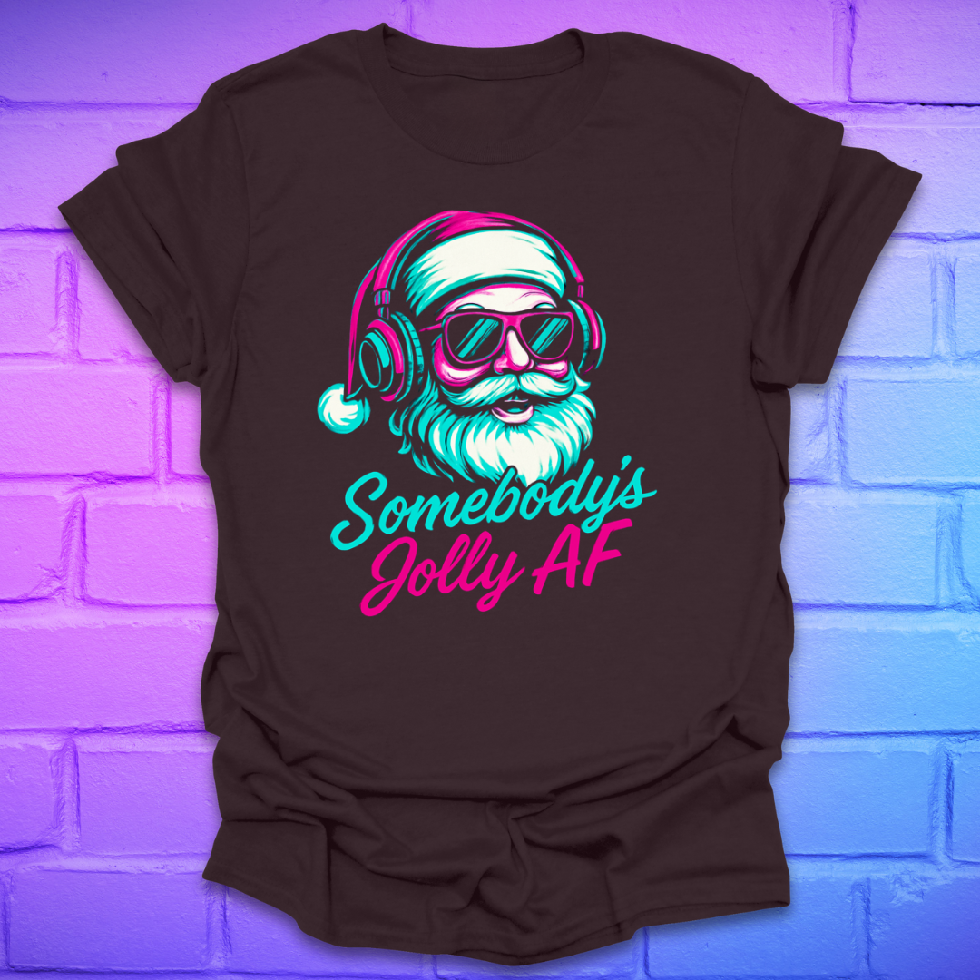 Brown t-shirt with a colorful graphic of Santa Claus wearing headphones and sunglasses, text 'Somebody's Jolly AF' on a brick wall background.