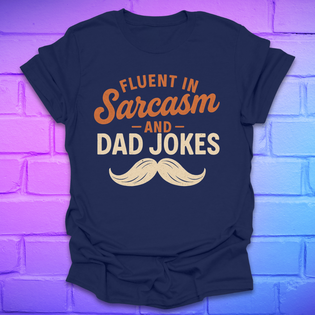Navy blue t-shirt with 'Fluent in Sarcasm and Dad Jokes' text and mustache graphic on a brick wall background.