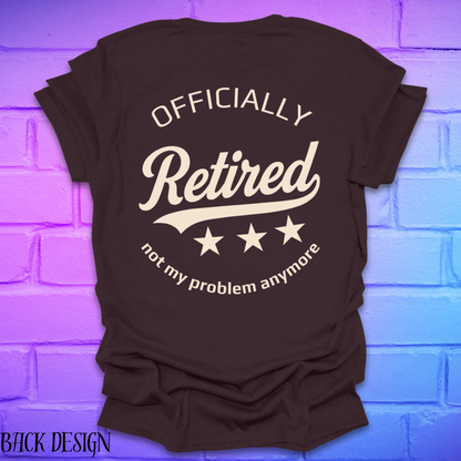 Brown t-shirt with 'Officially Retired, not my problem anymore' text on a brick wall background