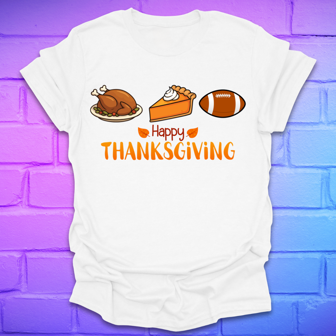 White t-shirt with thanksgiving theme and text, 'happy thanksgiving' with turkey, pie and football, on a brick background.
