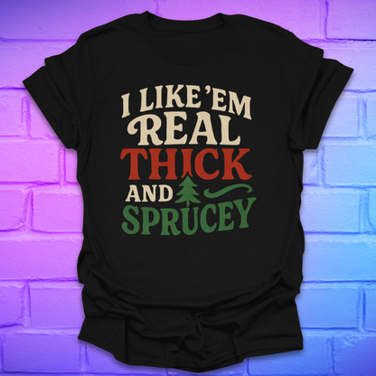 Black t-shirt with text, 'I like 'em real thick and sprucey' with a pine tree in white, red and green on a brick background.