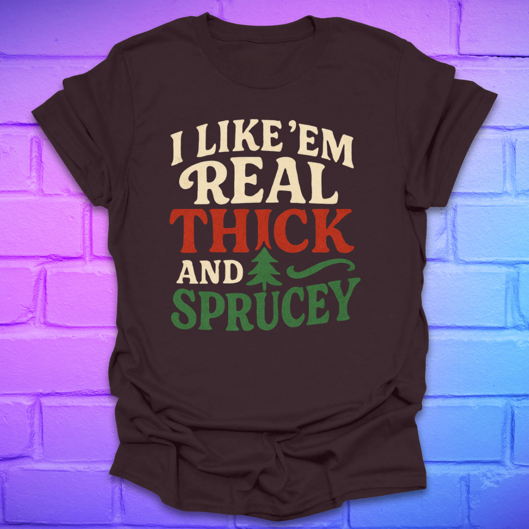 Brown t-shirt with text, 'I like 'em real thick and sprucey' with a pine tree in white, red and green on a brick background.