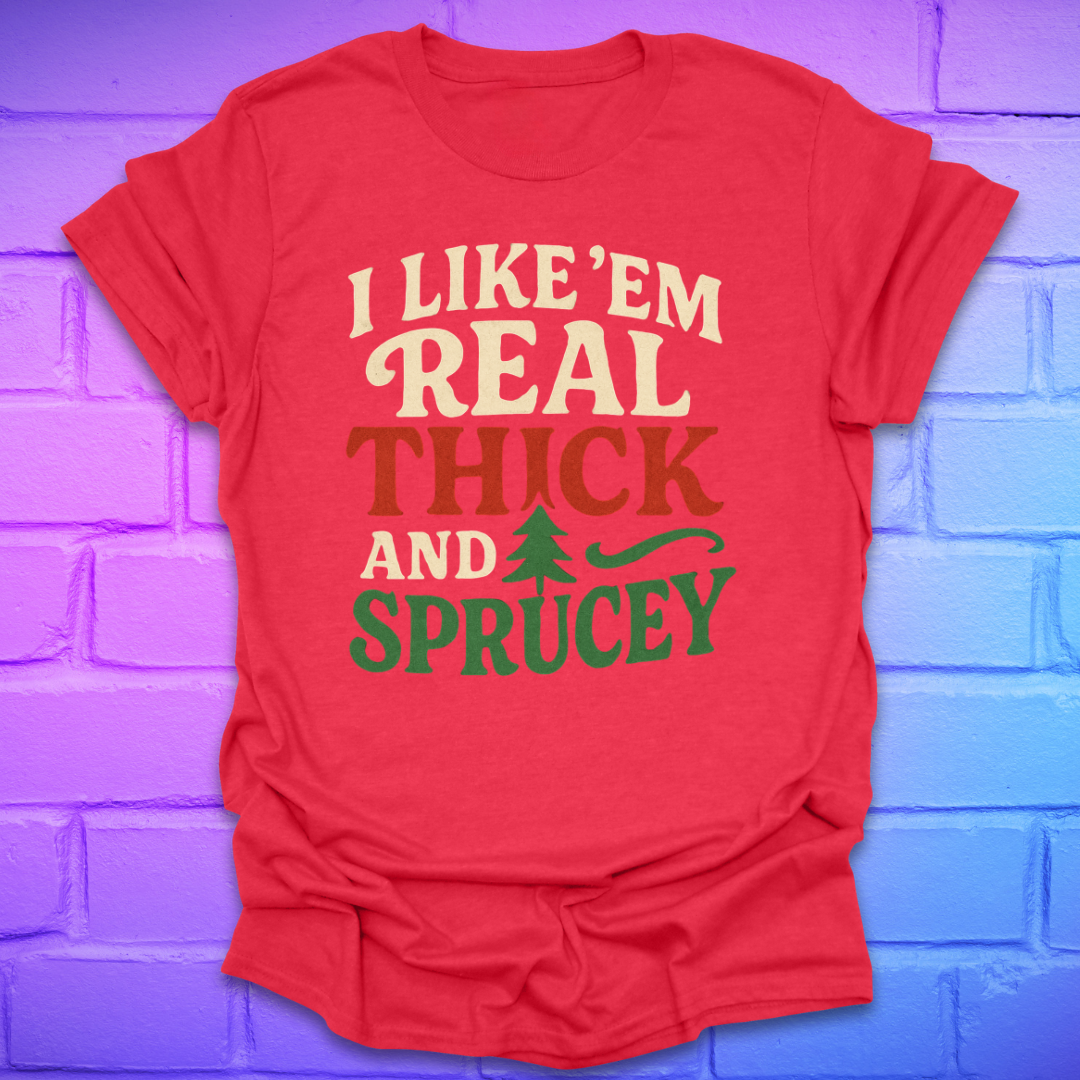 Red t-shirt with text, 'I like 'em real thick and sprucey' with a pine tree in white, red and green on a brick background.