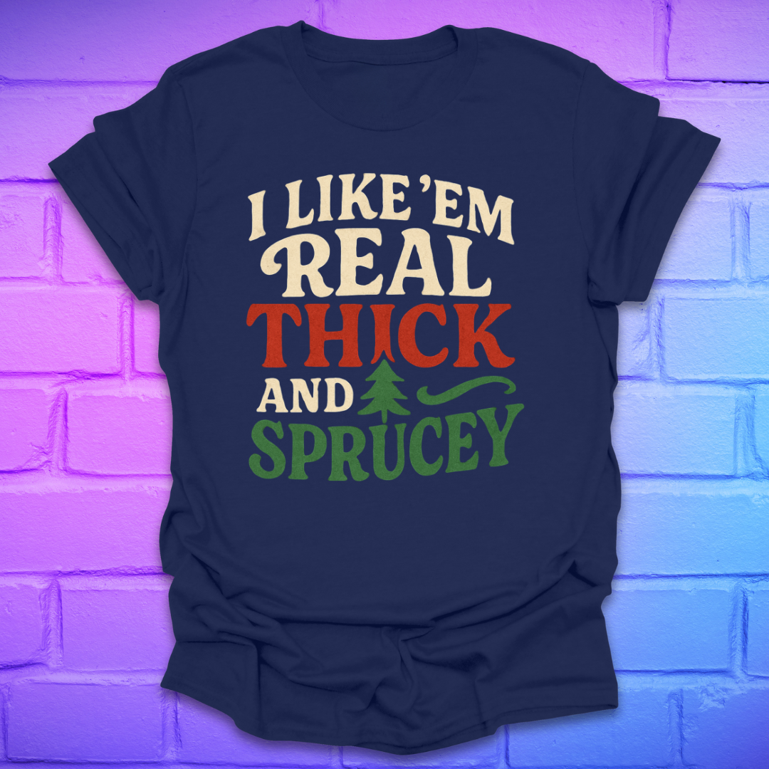 Navy blue t-shirt with text, 'I like 'em real thick and sprucey' with a pine tree in white, red and green on a brick background.