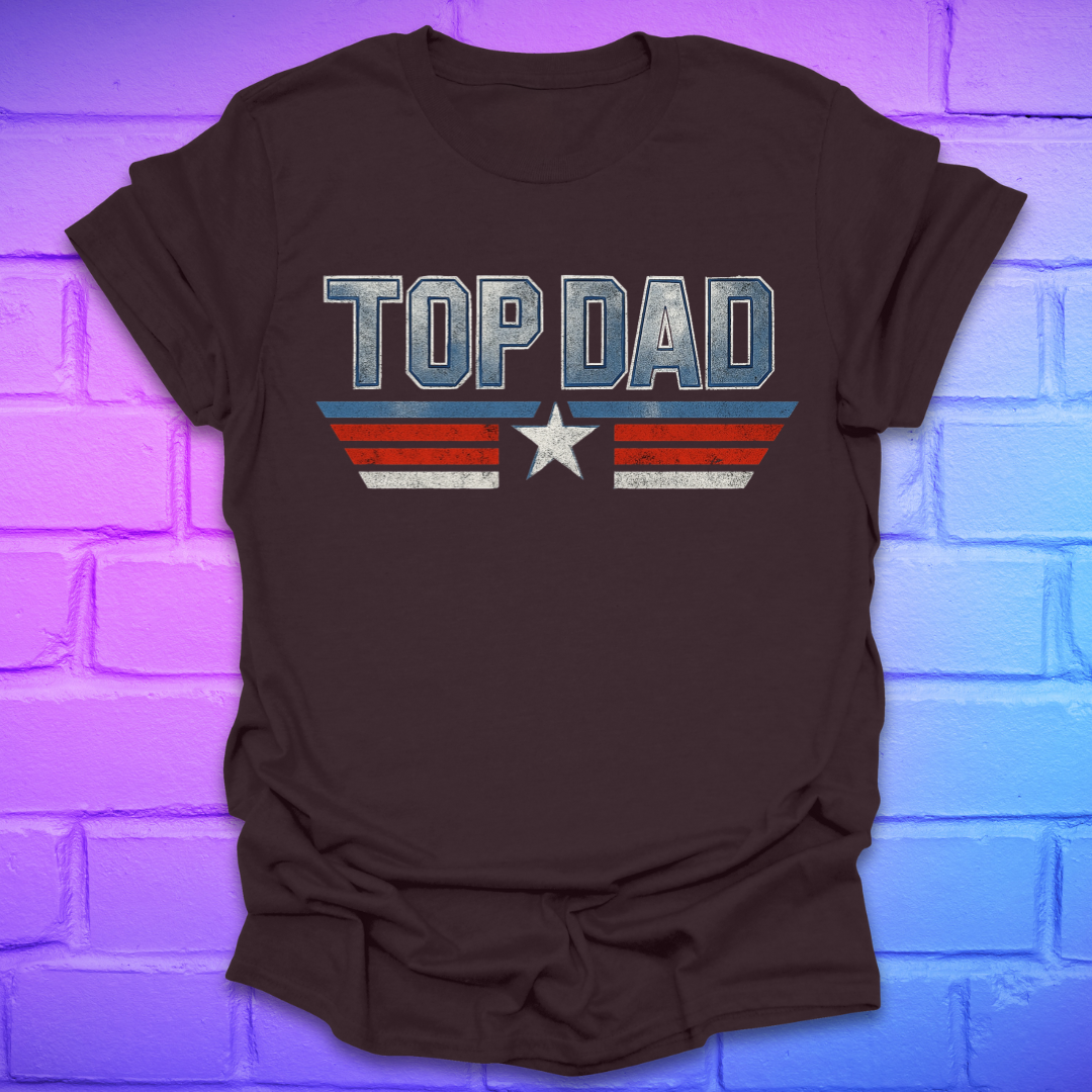 Brown t-shirt with text 'Top Dad' with red, white and blue stripes and a star on a brick background.