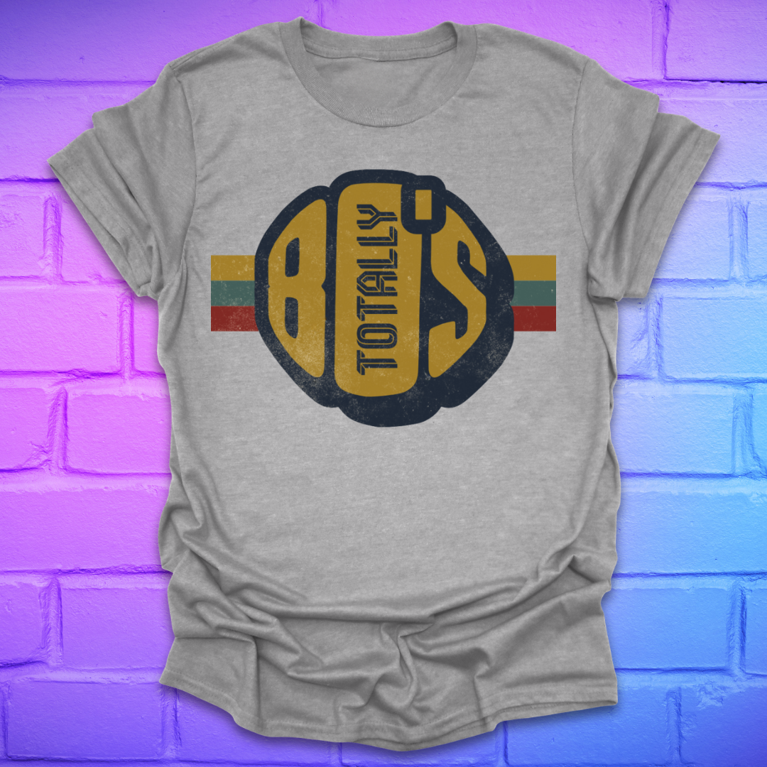 Grey t-shirt with a large retro graphic reading 'Totally 80's' with a colorful stripe on a brick background.