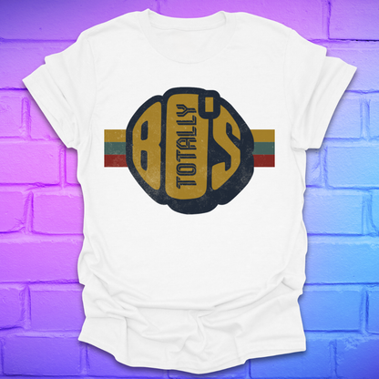 White t-shirt with a large retro graphic reading 'Totally 80's' with a colorful stripe on a brick background.