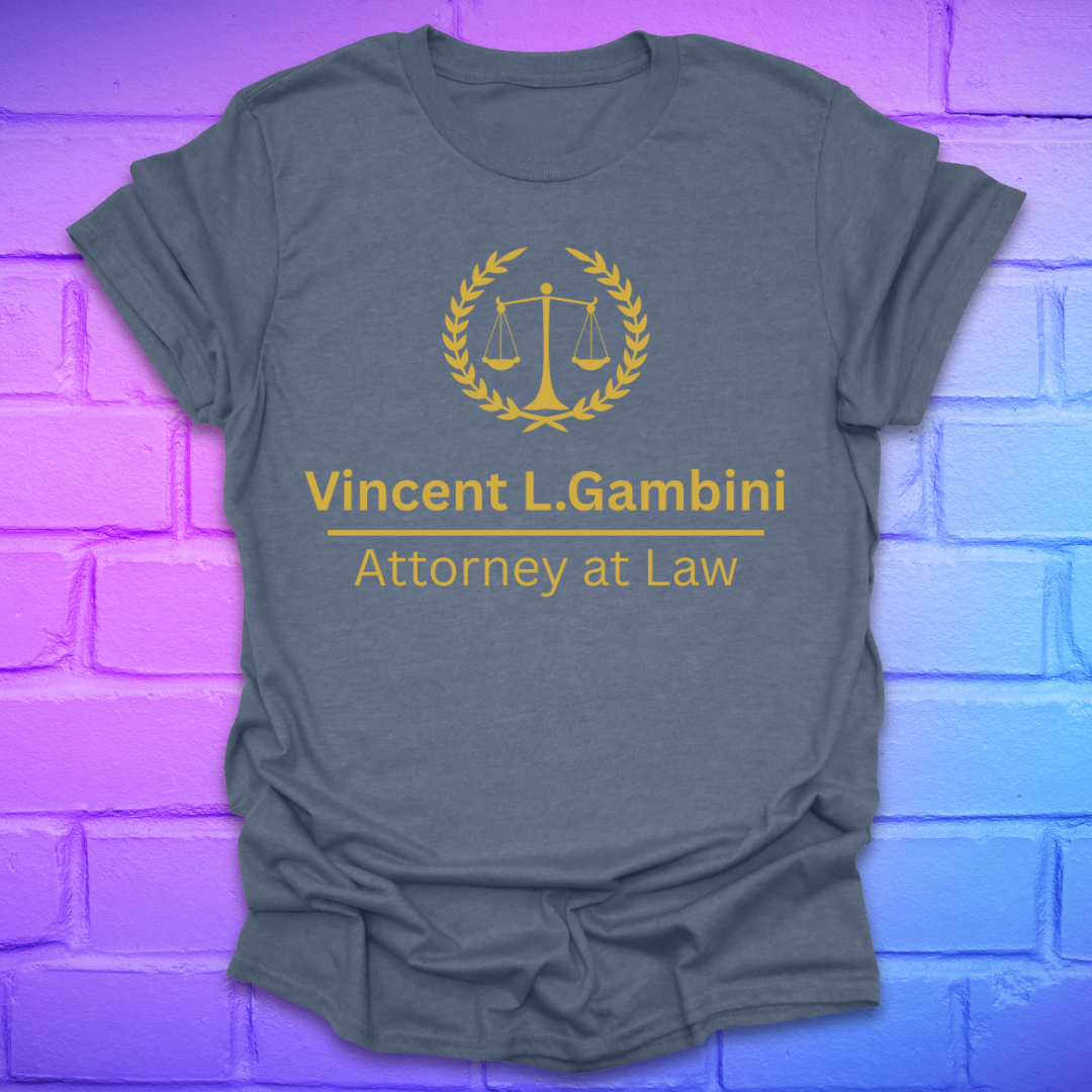 Gray t-shirt with yellow graphic and text on a brick wall background