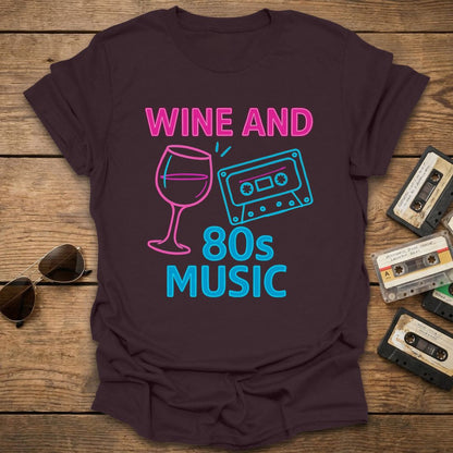 Brown t-shirt with 'Wine and 80s Music' design on a wooden surface with cassettes and sunglasses.