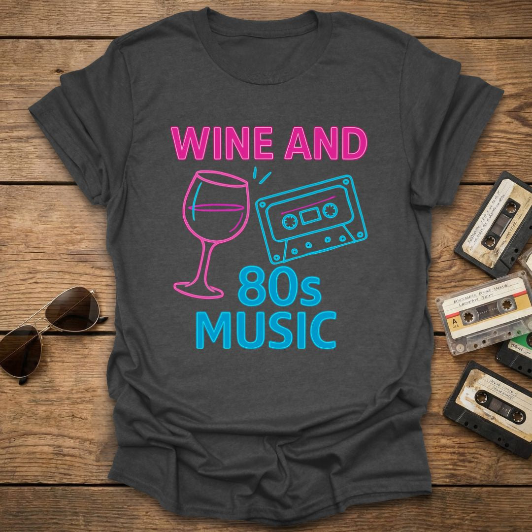 Gray t-shirt with 'Wine and 80s Music' design on a wooden surface with vintage cassettes and sunglasses.