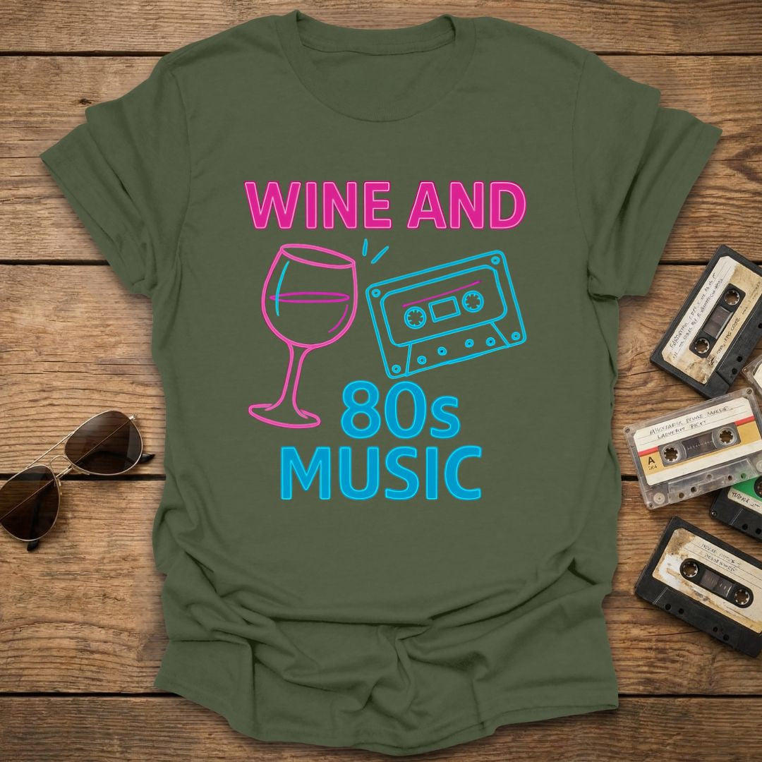 Green t-shirt with 'Wine and 80s Music' design on a wooden surface with cassettes and sunglasses.