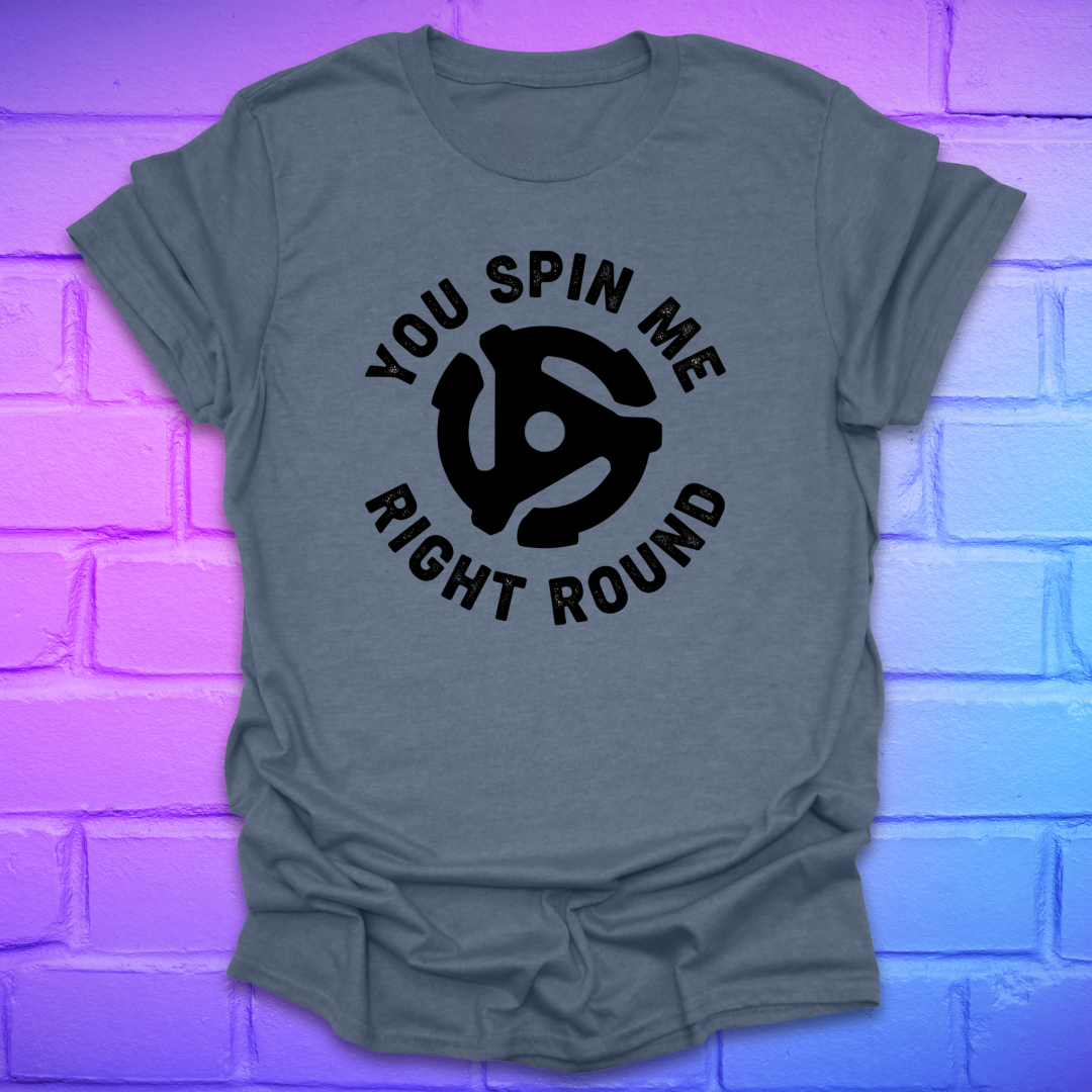 Indigo t-shirt with black graphic and text ,'you spin me right round' on a purple brick wall background